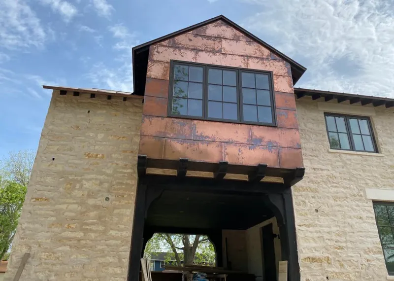Copper metal panel facade on a stone building for Roof Repair in Darien